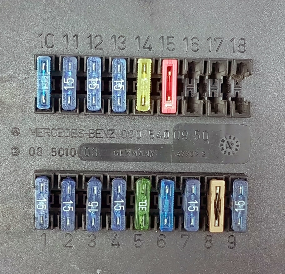 Vue détaillée des fusibles du tableau de bord derrière le couvercle de protection.